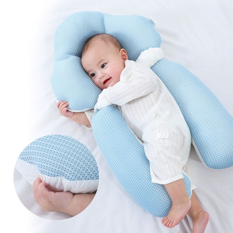 White U-shaped baby support cushion with side handles and a baby resting inside